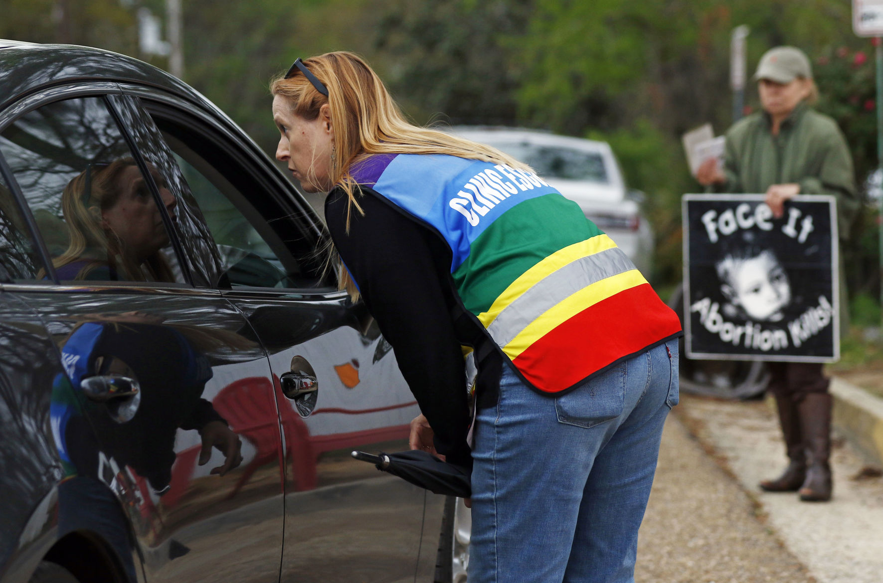 Clinic escort Kim Gibson speaks with driver